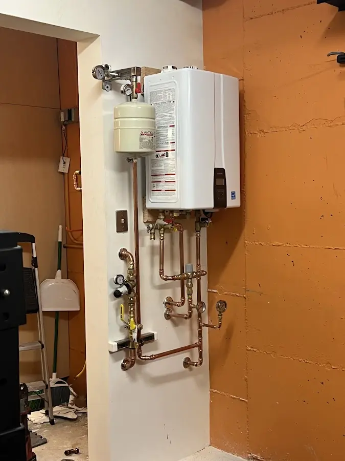 Plumbing technician inspecting water heater connections in Holmdel
